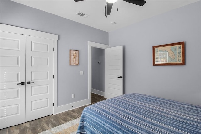 bedroom with dark hardwood / wood-style floors, ceiling fan, and a closet