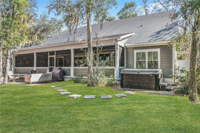 rear view of house featuring central AC unit, a yard, a hot tub, and a sunroom