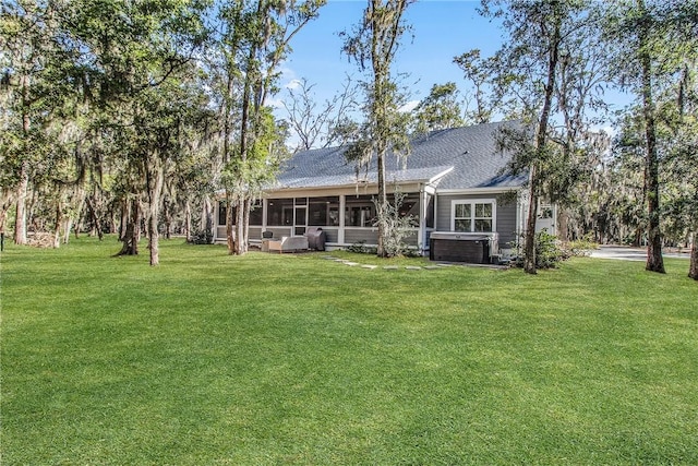 rear view of house featuring a yard, a hot tub, a sunroom, and central air condition unit