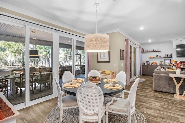 dining area with dark wood-type flooring and ornamental molding