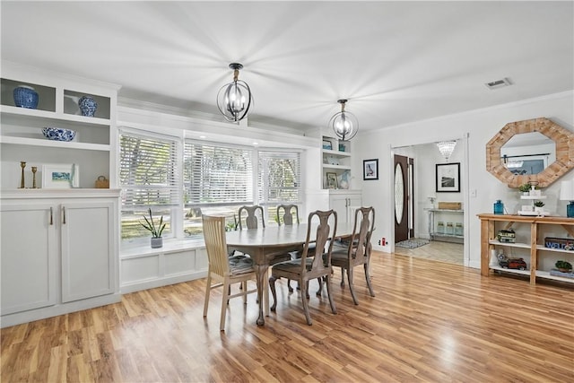 408 Couper Ave, Saint Simons Island, GA 31522 - dining area with light wood-style flooring, a chandelier, and ornamental molding