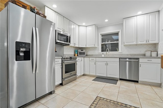 408 Couper Ave, Saint Simons Island, GA 31522 - kitchen with appliances with stainless steel finishes, a sink, light tile patterned flooring, backsplash, and light countertops