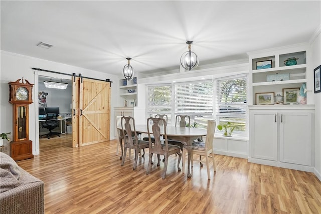 408 Couper Ave, Saint Simons Island, GA 31522 - dining area with a barn door, light wood-style flooring, and crown molding