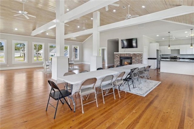 dining room with light wood-type flooring, high vaulted ceiling, and wood ceiling