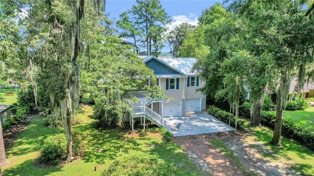 view of front of house with stairway, an attached garage, concrete driveway, and a front yard