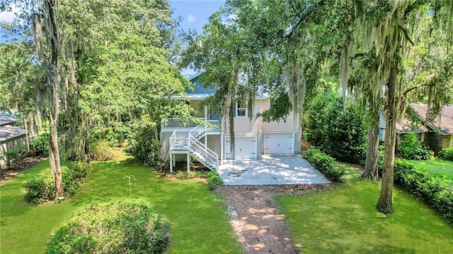 exterior space featuring stairway, an attached garage, and concrete driveway