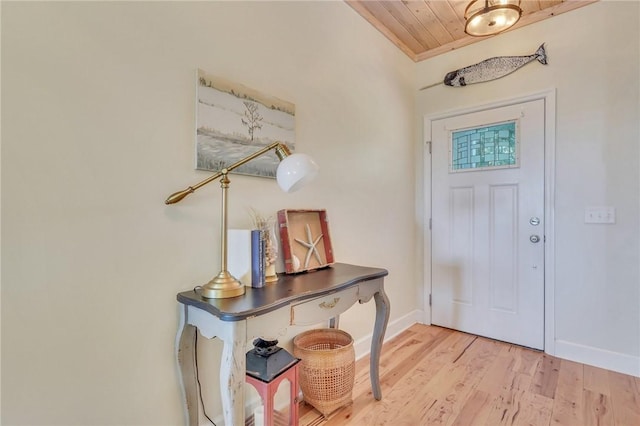 foyer entrance with wooden ceiling, wood finished floors, and baseboards