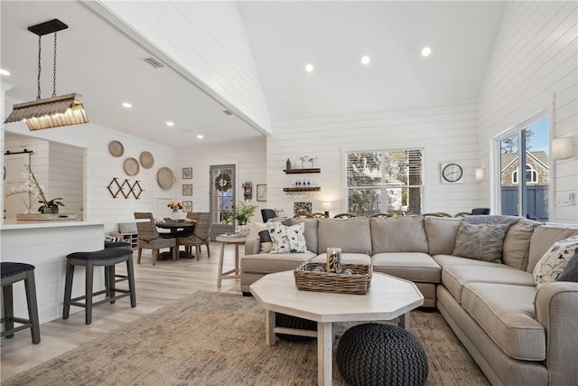 living room with light wood-type flooring and a high ceiling