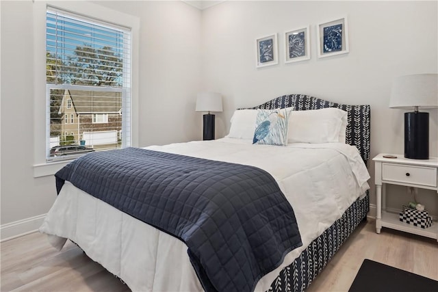 bedroom featuring multiple windows and light wood-type flooring