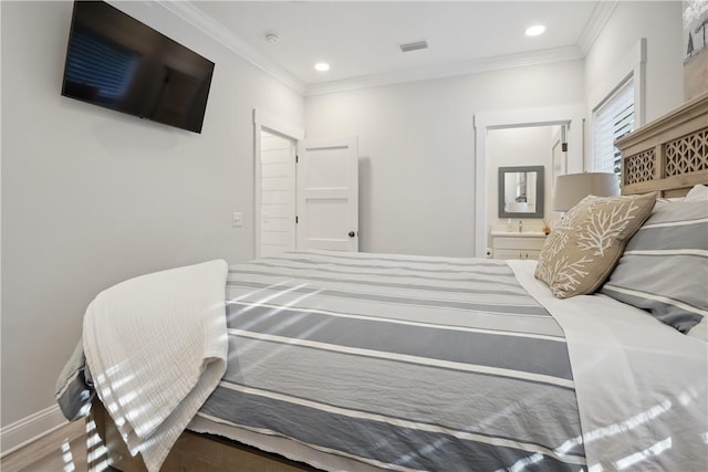 bedroom with ornamental molding, wood-type flooring, and ensuite bathroom