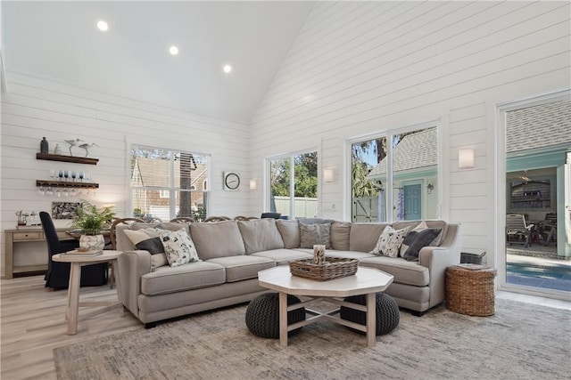 living room featuring high vaulted ceiling and light wood-type flooring