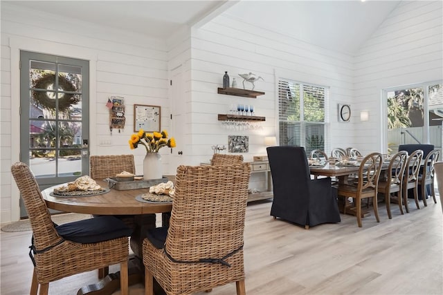 dining space featuring lofted ceiling and light hardwood / wood-style flooring