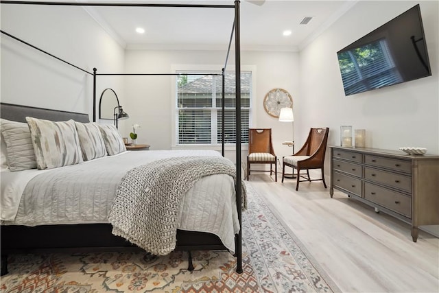 bedroom with ornamental molding and light hardwood / wood-style flooring