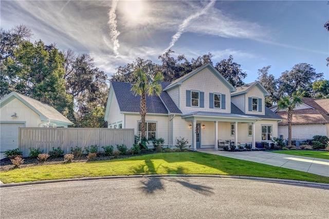 view of front of property featuring a garage, a porch, and a front lawn