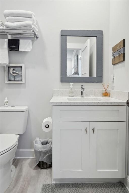 bathroom with vanity, hardwood / wood-style flooring, and toilet