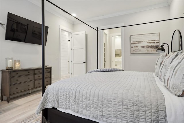 bedroom featuring connected bathroom, light hardwood / wood-style flooring, and ornamental molding