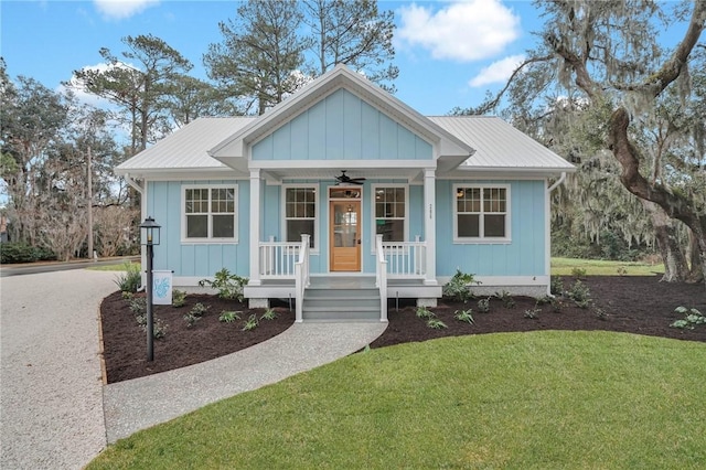 view of front of home with a front yard, ceiling fan, and covered porch