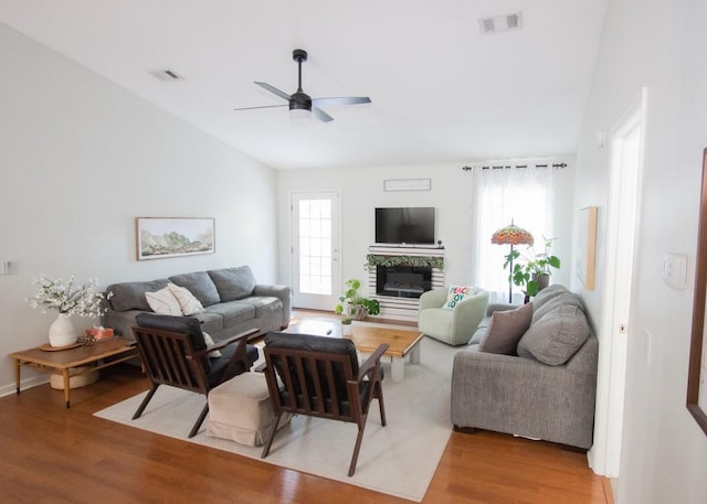 living room featuring vaulted ceiling, ceiling fan, and hardwood / wood-style floors