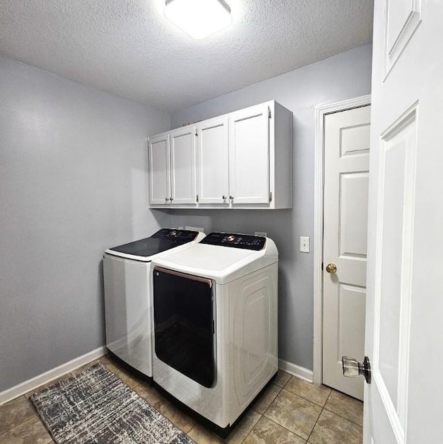 washroom featuring cabinets, light tile patterned floors, independent washer and dryer, and a textured ceiling