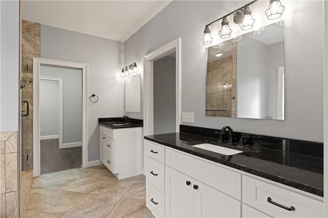 bathroom with tile patterned flooring, vanity, and walk in shower