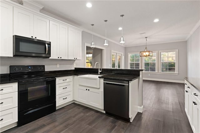 kitchen with sink, white cabinetry, hanging light fixtures, and appliances with stainless steel finishes