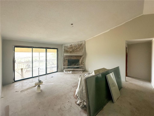 47 Marsh View Ct, Saint Marys, GA 31558 - unfurnished living room featuring a stone fireplace, a textured ceiling, and vaulted ceiling