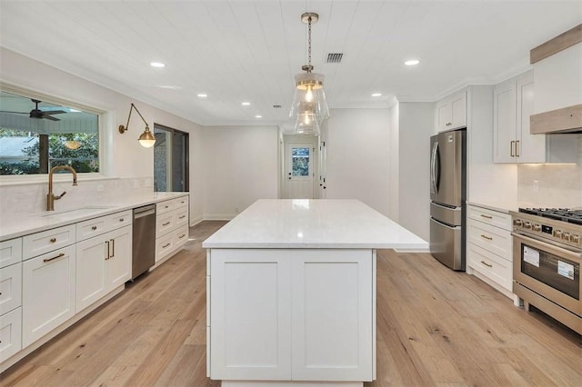 kitchen featuring tasteful backsplash, appliances with stainless steel finishes, a center island, and a sink