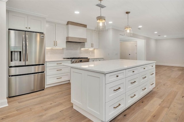 kitchen featuring decorative backsplash, light countertops, stainless steel refrigerator with ice dispenser, wall chimney range hood, and light wood-type flooring