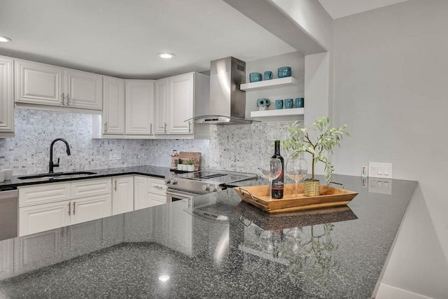 kitchen featuring wall chimney exhaust hood, decorative backsplash, white cabinetry, and sink