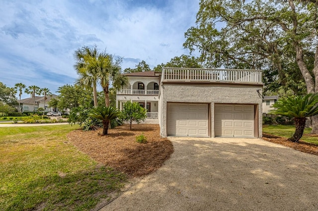 view of front of property with a balcony, a front lawn, and a garage