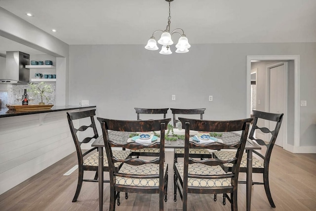 dining area featuring a notable chandelier and light hardwood / wood-style floors