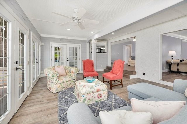 living room featuring french doors, light wood-type flooring, and ceiling fan