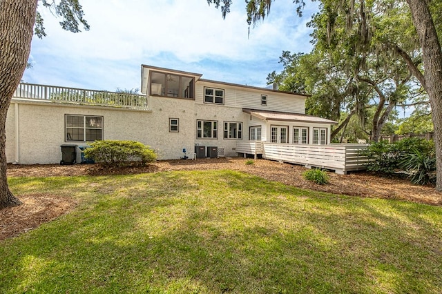 back of property with a yard, central air condition unit, a deck, and a sunroom