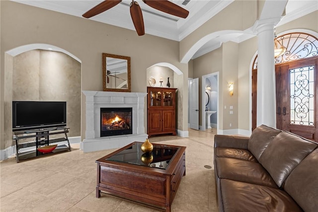 living room featuring light tile patterned floors, ornamental molding, ceiling fan, beam ceiling, and decorative columns