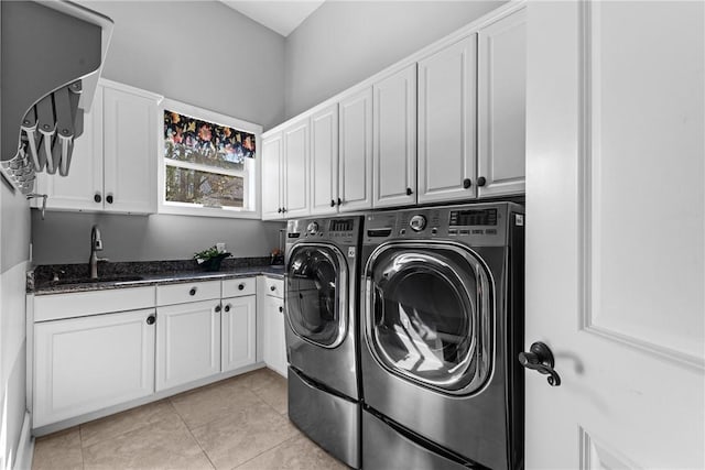 washroom featuring cabinets, washing machine and clothes dryer, light tile patterned flooring, and sink