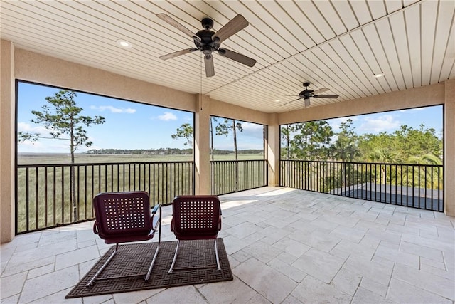 unfurnished sunroom with ceiling fan and wooden ceiling