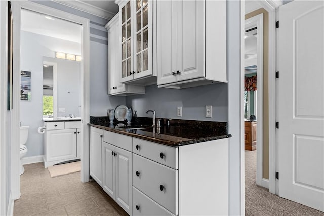 kitchen with sink, white cabinets, and dark stone counters