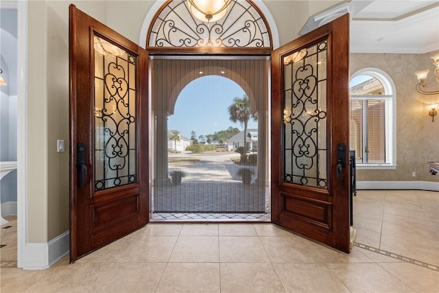 tiled foyer entrance with crown molding