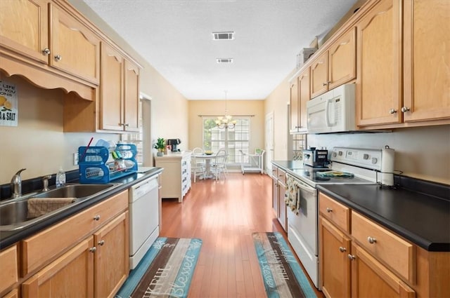 118 Drayton Cir, Brunswick, GA 31525 - kitchen with white appliances, dark wood finished floors, dark countertops, a chandelier, and decorative light fixtures