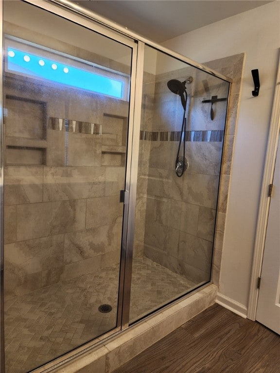 bathroom featuring a shower stall and wood finished floors