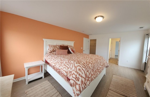 bedroom featuring visible vents, baseboards, and wood finished floors