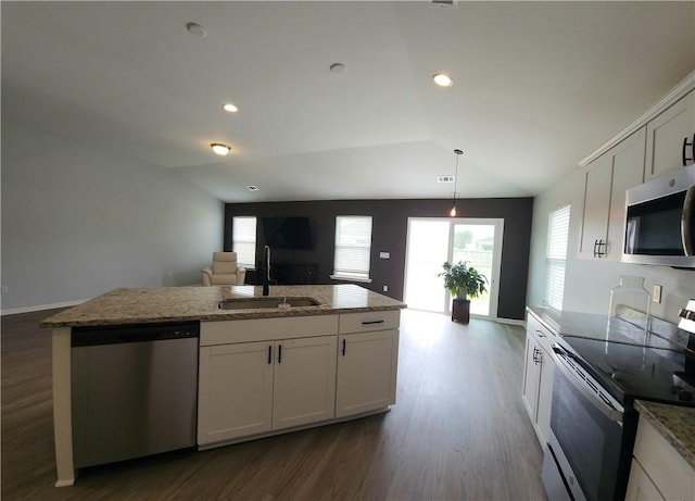 kitchen featuring a sink, light stone counters, dark wood-style flooring, and stainless steel appliances