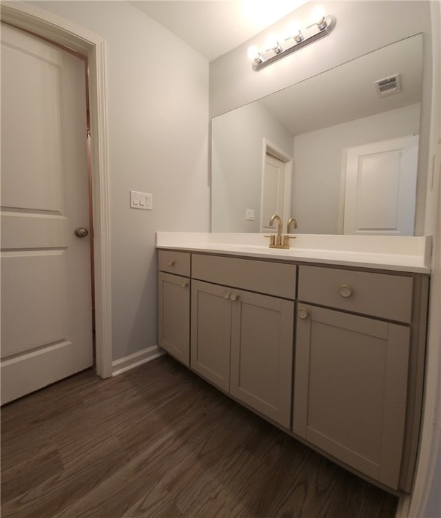 bathroom with visible vents, baseboards, wood finished floors, and vanity