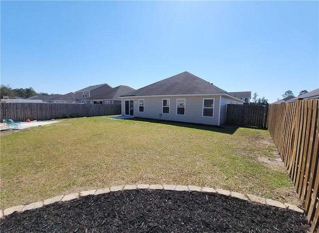 rear view of property with a yard and a fenced backyard