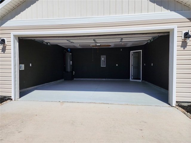 garage with electric panel, driveway, and water heater