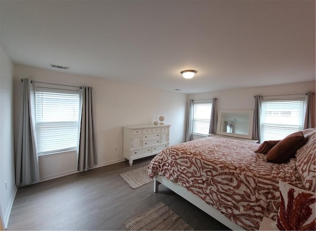 bedroom featuring dark wood finished floors, baseboards, and visible vents