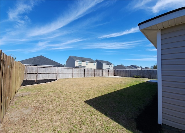 view of yard with a fenced backyard and a residential view