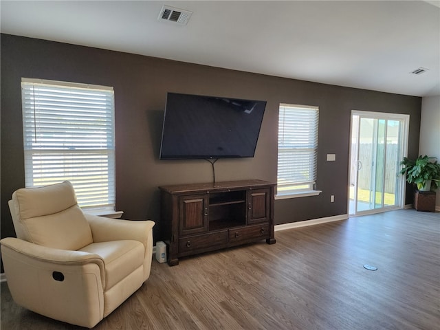 living room with light wood-style flooring, baseboards, and visible vents