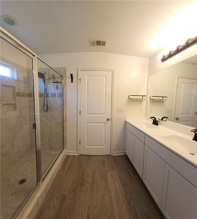 bathroom featuring visible vents, a shower stall, and a sink