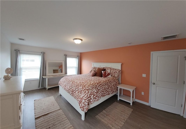 bedroom with baseboards, visible vents, and dark wood-style flooring